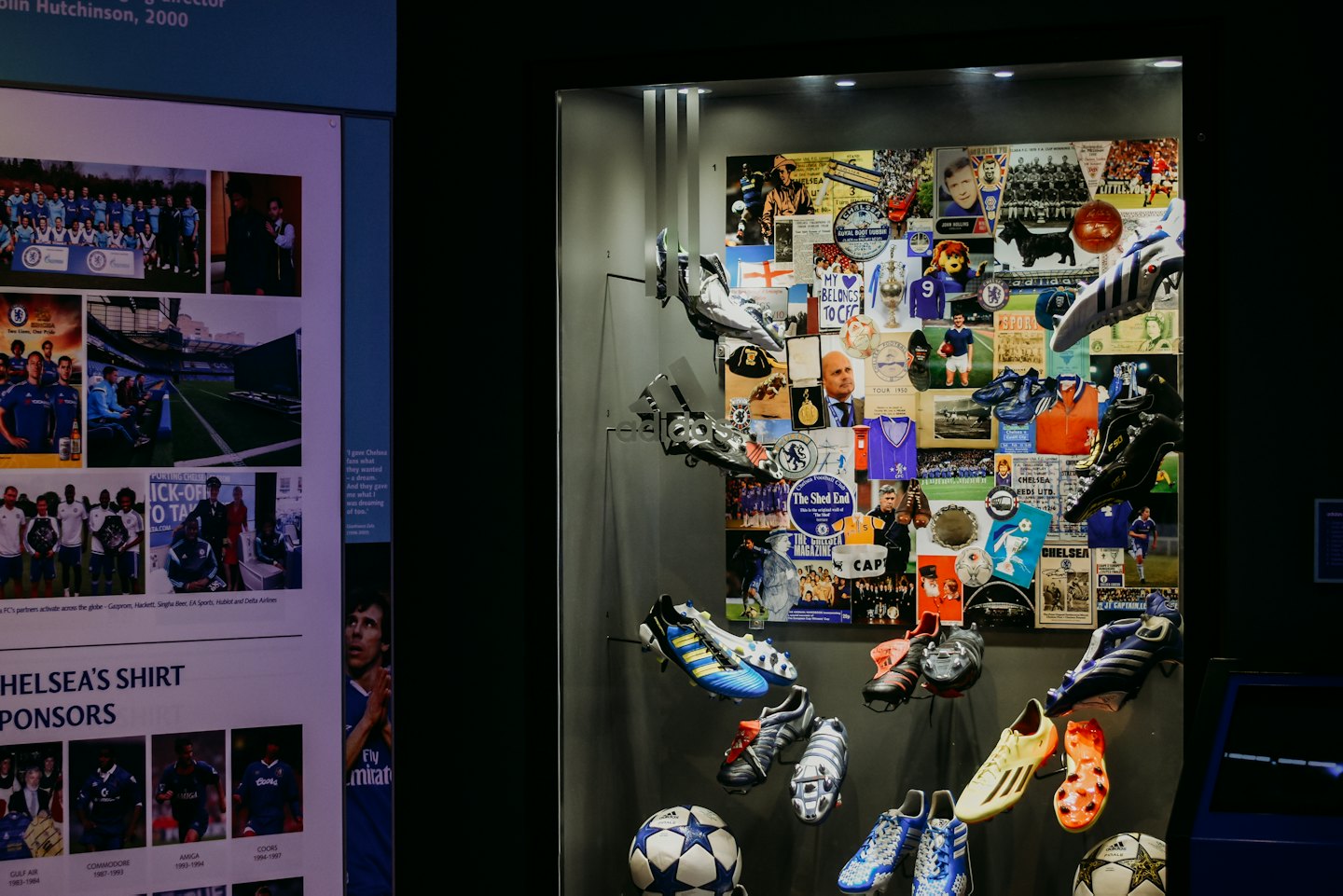 Sports museum exhibit displays vintage football boots and historical memorabilia.